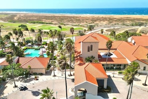 Ein Resort mit Swimmingpool, Palmen und Blick auf den Ozean.