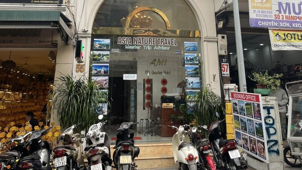 The exterior of the AMI Old Quarter Hotel with a prominent entrance, a booking office sign, and several motorcycles parked in front. - AMI Old Quarter Hotel (Hanoi)
