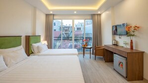 A hotel room with two beds, a desk, a TV, and a balcony with a view of buildings. - AMI Old Quarter Hotel (Hanoi)