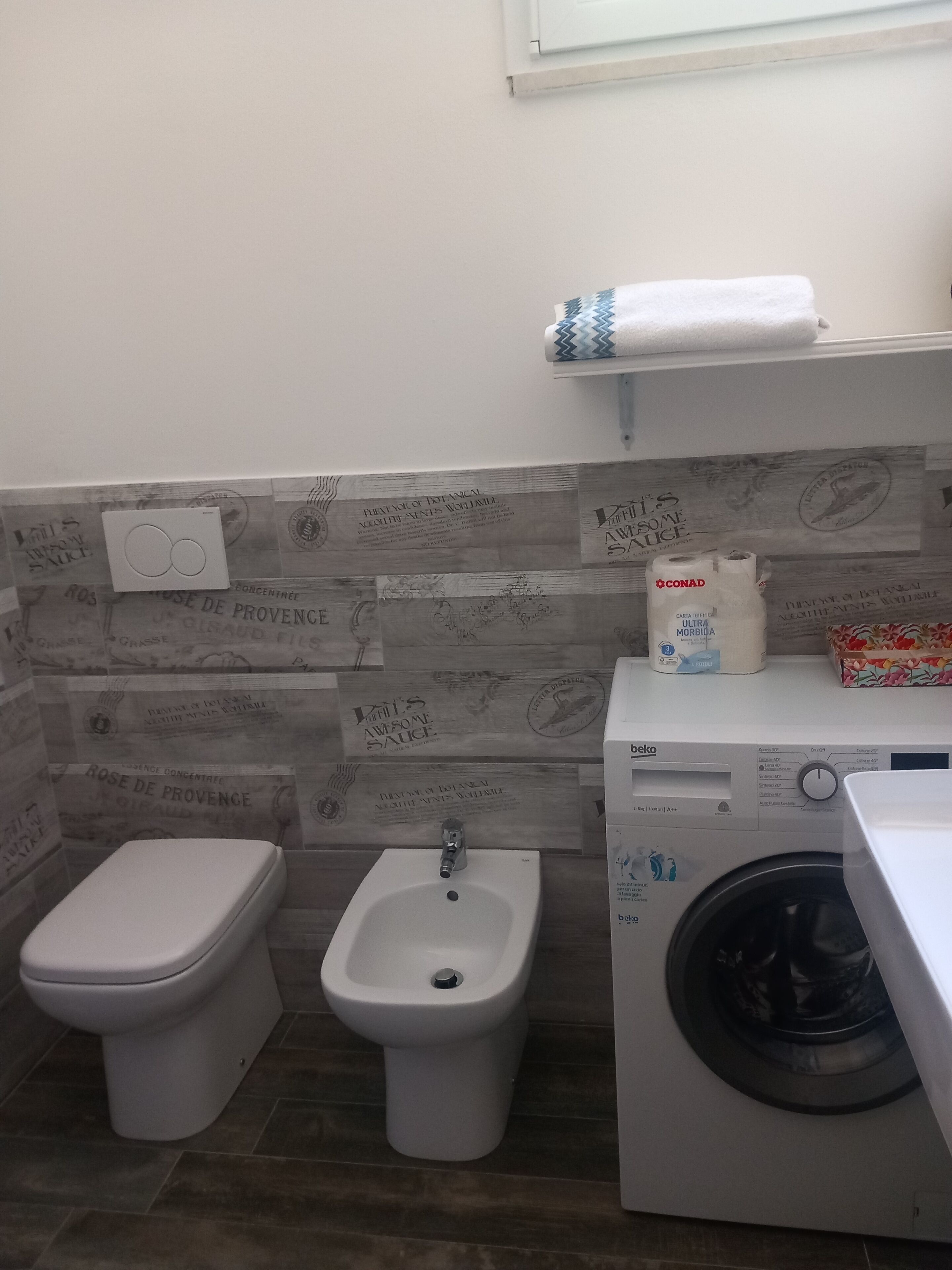 Une petite salle de bain comprenant des toilettes, un bidet et un lave-linge.