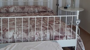 Een kamer met een bed, een klein tafeltje en een lamp.