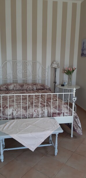 Ein Zimmer mit einem Bett, einem kleinen Tisch und einer Lampe.
