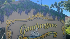 Une pancarte avec l’inscription « Goudargues, la Venise du Gard » et une illustration représentant un cygne.
