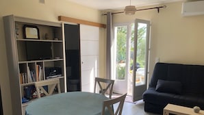 Un salon comprenant une table à manger, un canapé et une bibliothèque.