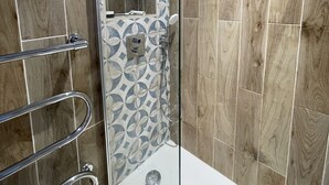 A modern bathroom with a shower, a toilet, and a sink.