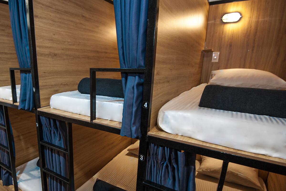 A bunk bed room with wooden walls and a small light fixture above the beds.