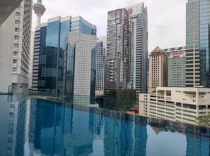Un horizonte urbano moderno con rascacielos y una piscina reflectante.