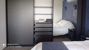 A bedroom with a bed, a wardrobe, a desk with a chair, and a bedside table. - Location Estivale Bastia U Fiumicellu, Vue Mer. Jacuzzi, Barbecue, (Bastia)