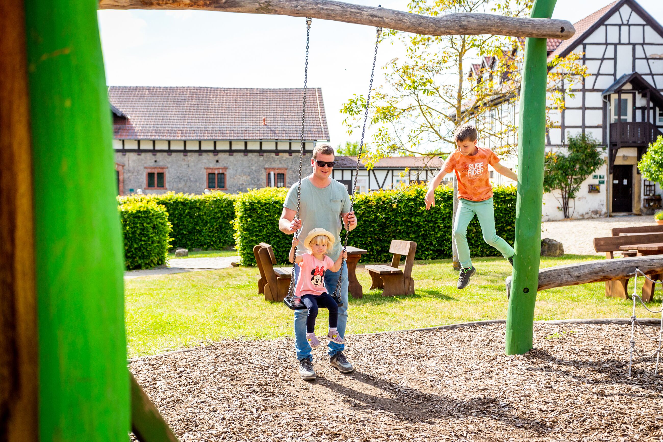 A playground with swings and a wooden structure.