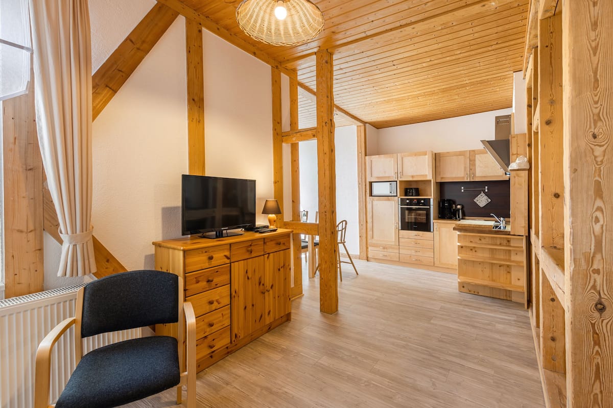 Un intérieur en bois comprenant un téléviseur, des placards en bois et un coin cuisine.