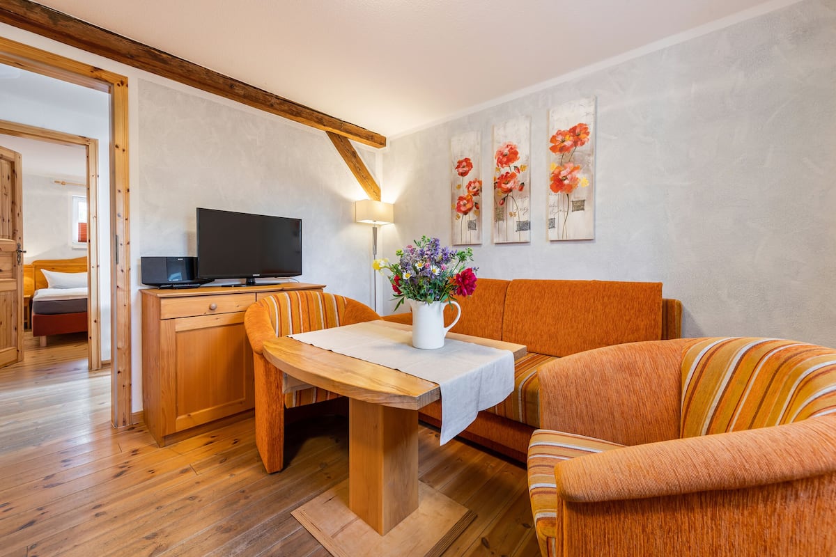 Un salon chaleureux avec une table à manger en bois, un canapé et un téléviseur.