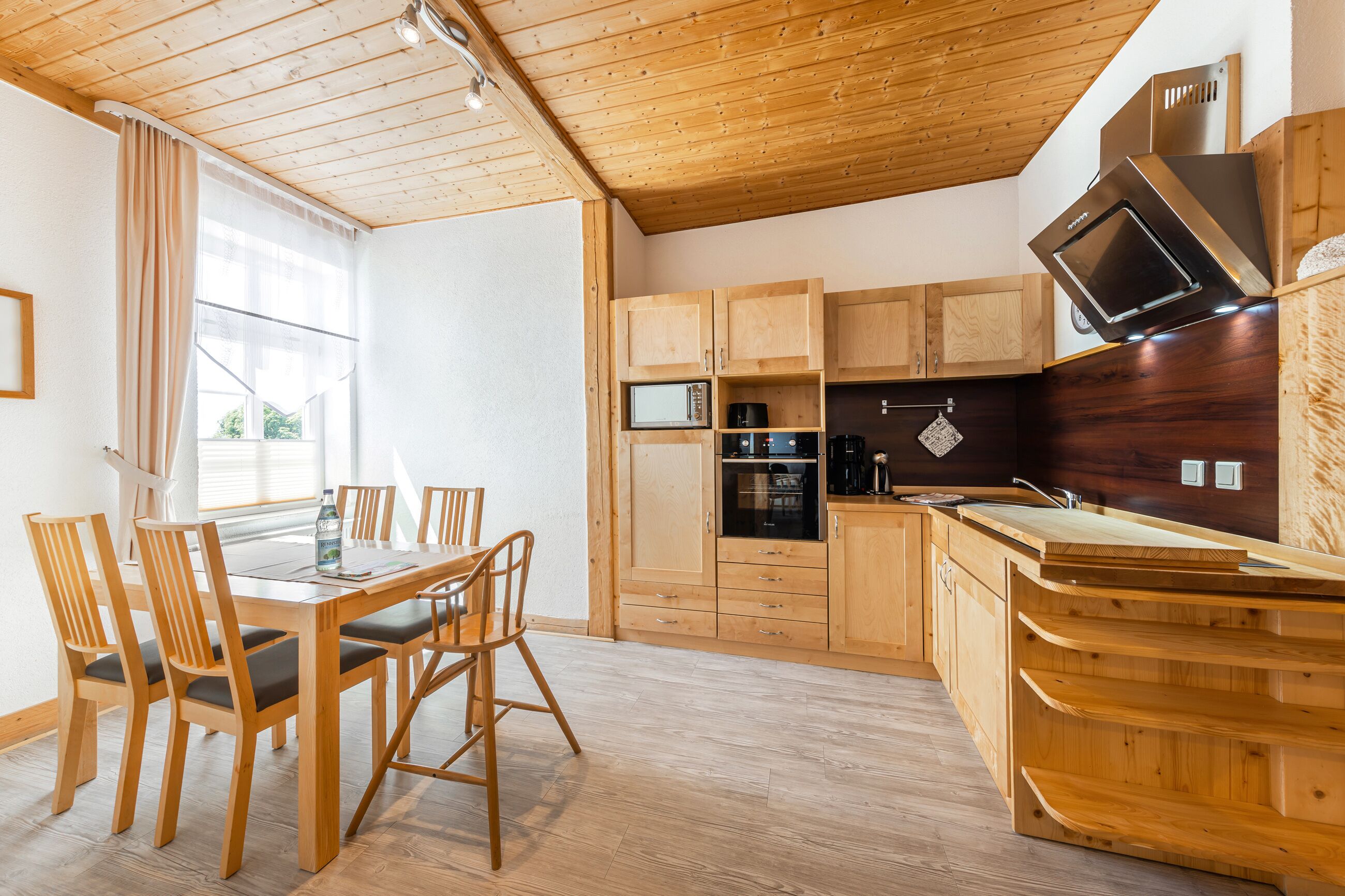 Une cuisine moderne avec des meubles en bois et un four à micro-ondes encastré.