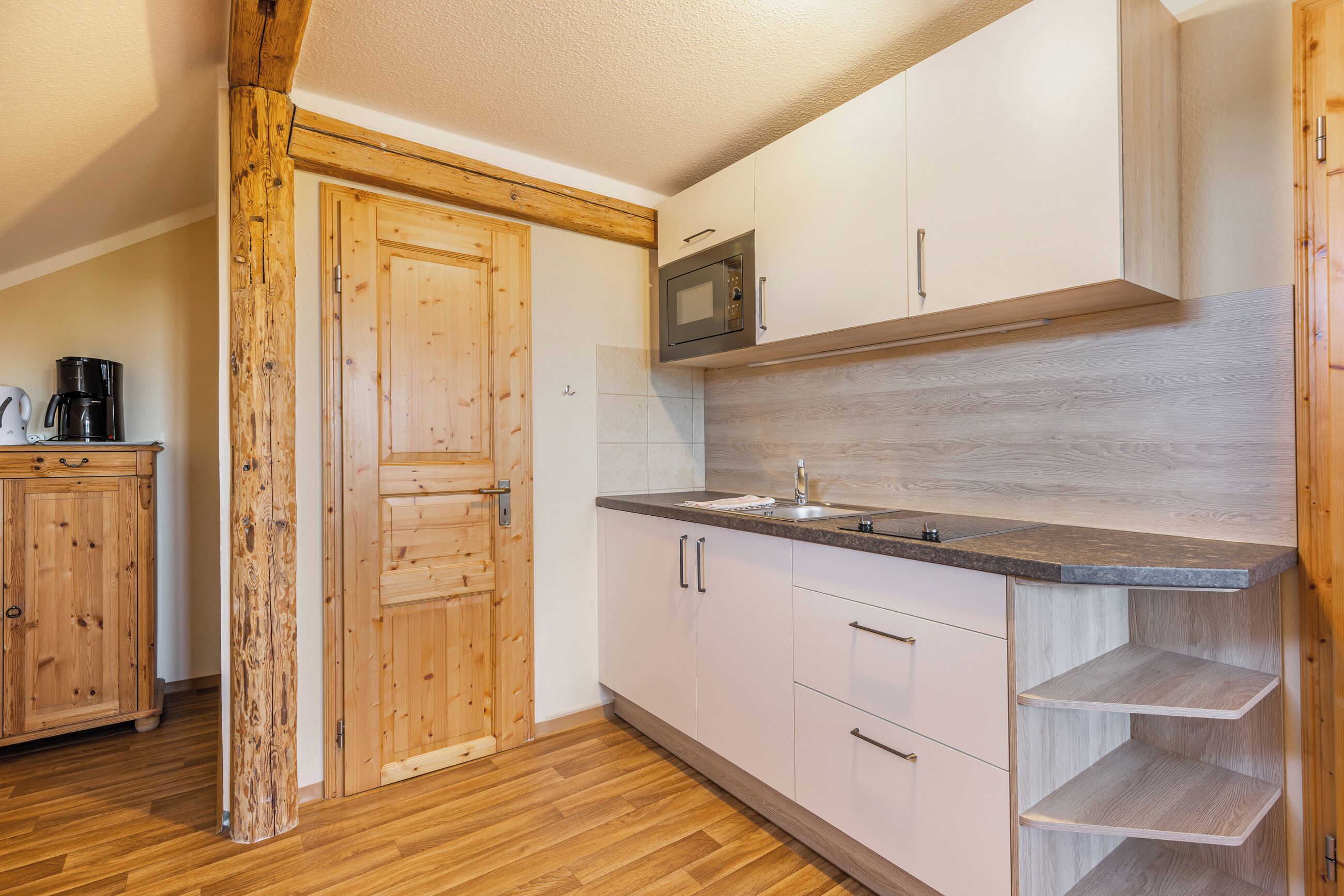 Una cocina moderna con armarios de madera, un microondas integrado y una encimera de granito.