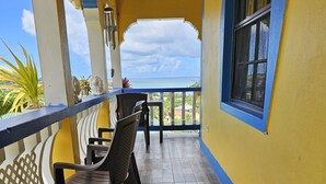 Un balcon avec vue sur la mer, doté d’un plancher en bois, d’une table et de chaises.