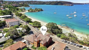 A coastal area with a beach, boats, and a sign indicating 'The Esplanade'. - Luxe-Coastal Balmoral Beachfront (Mosman)