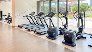 A modern gym with treadmills, elliptical machines, and weight stations. - Maison Privee - Luxury Apt with Burj Khalifa Vw & Direct Mall Access (Dubai)