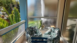 A balcony with two chairs and a small table, overlooking a garden with various plants and a fountain. - Arcachon: Central T2, Close to Casino, Beach & Shops, Private Parking (Arcachon)