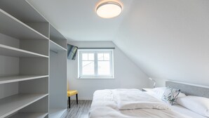 A bedroom with a bed, a window, and built-in shelving. - Vacation apartment Achterdeck in Drelsdorf for up to 4 people (Drelsdorf)