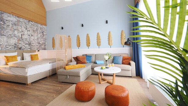 Un salon moderne avec un canapé, un pouf et une table basse.