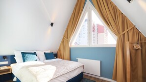 Una camera da letto con un letto, una finestra con tende, un comodino e una lampada a parete.