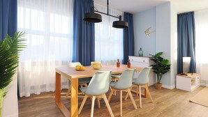 Een moderne eetruimte met een houten tafel, vier stoelen en een kroonluchter.