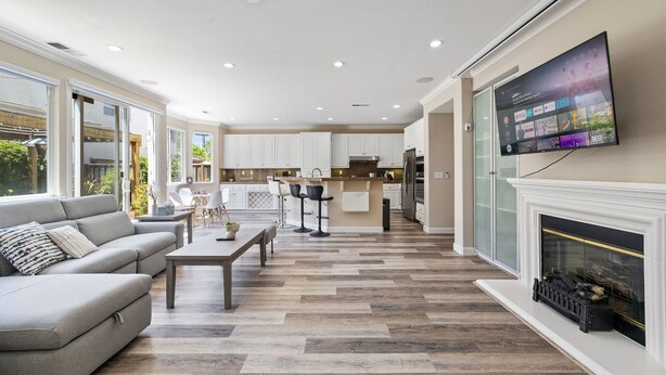 A modern living room with a sofa, coffee table, and fireplace. - 5BR Home Modern & Spacious for Business & Family (San Jose)
