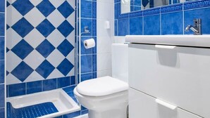 Ein Badezimmer mit Dusche, Toilette und Waschbecken.