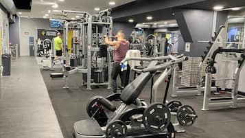 A gym with various exercise equipment, including a bench press and weight machines.