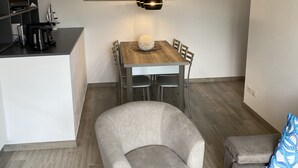 Et moderne køkken med spisebord, stole og kaffemaskine.
