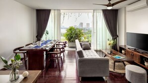 Una sala de estar moderna con sofá, mesa de comedor y televisor.