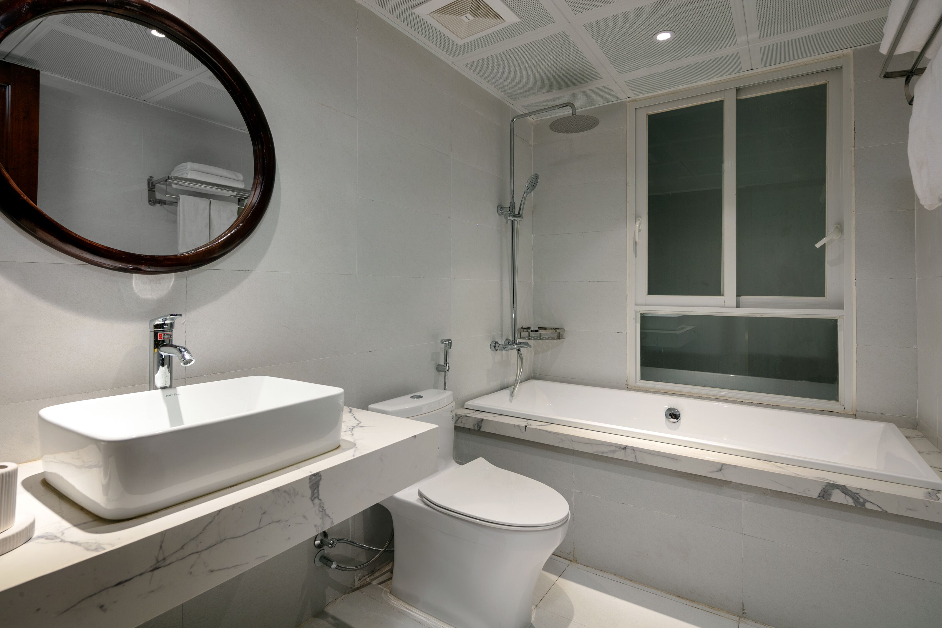 A modern bathroom with a rectangular sink, a toilet, and a bathtub.