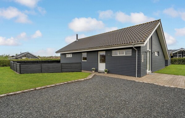 A modern two-story house with a grey exterior, a sloped roof, and a gravel driveway. - Gorgeous home in Tarm with WiFi (Tarm)