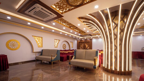 A spacious lobby with a polished marble floor, seating areas, and decorative wall panels. - The Royal Bihar (Danapur)