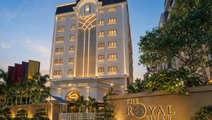 A hotel with a prominent entrance, a large sign with the hotel's name, and a well-maintained garden area. - The Royal Bihar (Danapur)