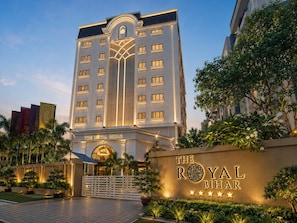 A hotel with a prominent entrance, a large sign with the hotel's name, and a well-maintained garden area. - The Royal Bihar (Danapur)