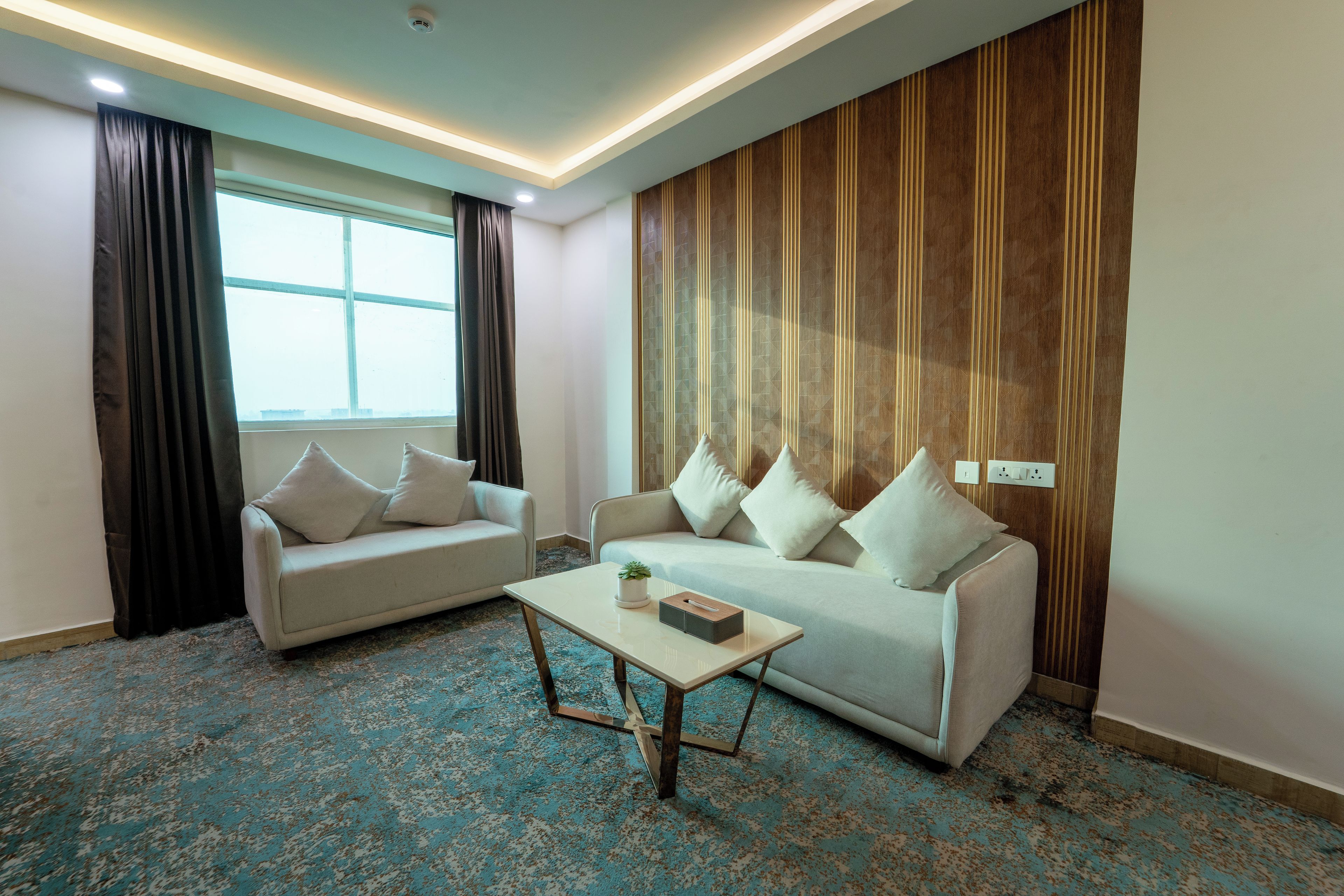 Un salon moderne avec deux canapés, une table basse et un tapis à motifs.