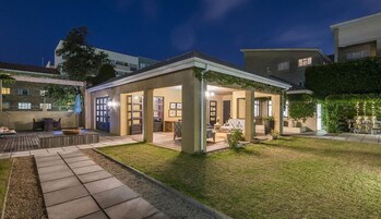 Un espacio al aire libre techado con asientos, un brasero y vistas de los edificios circundantes.