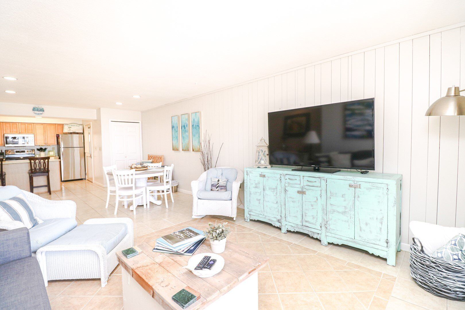 A living room with a TV, a dining area, and a kitchen.