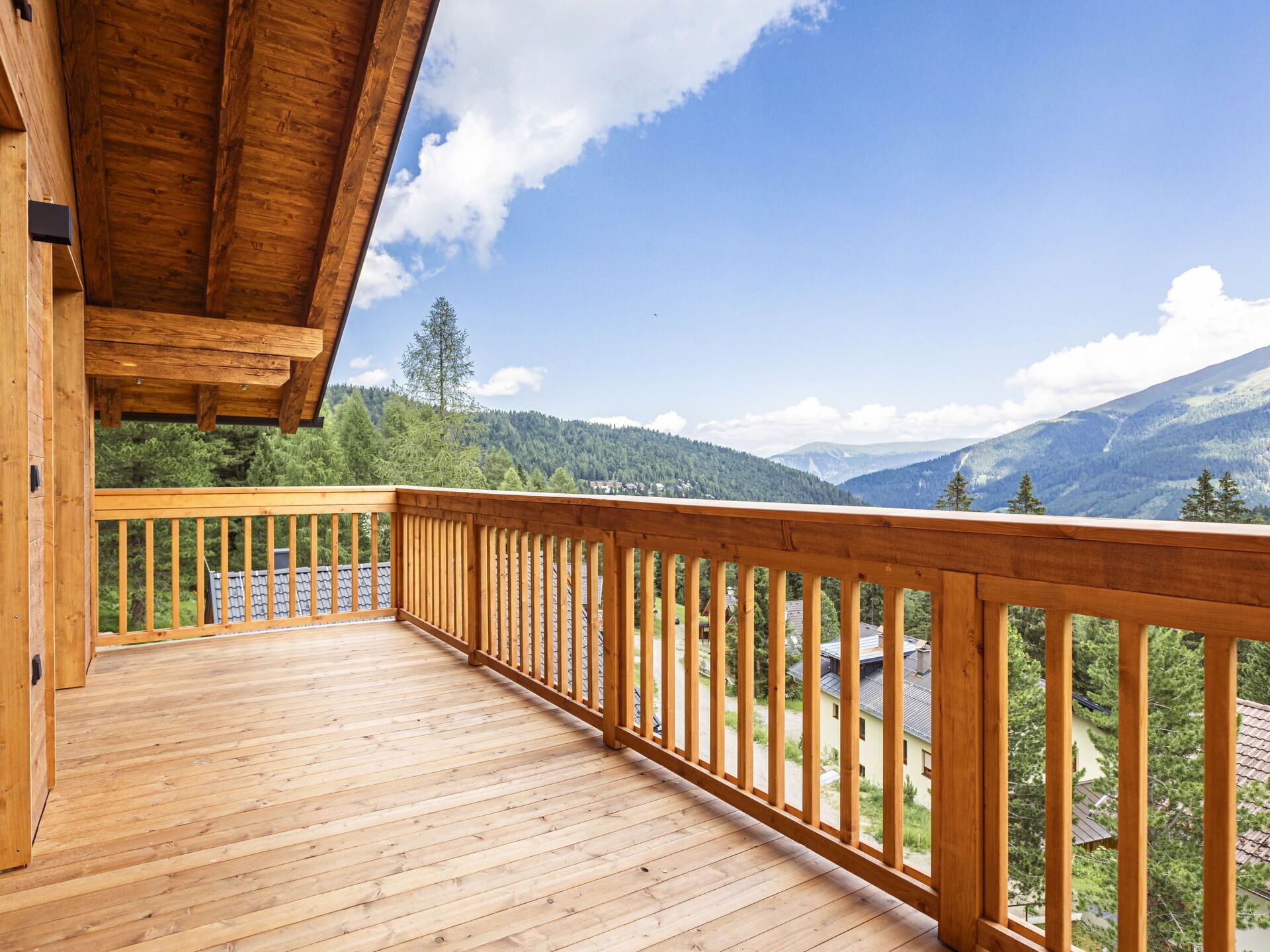 Eine Holzterrasse mit Geländer mit Blick auf eine Berglandschaft.