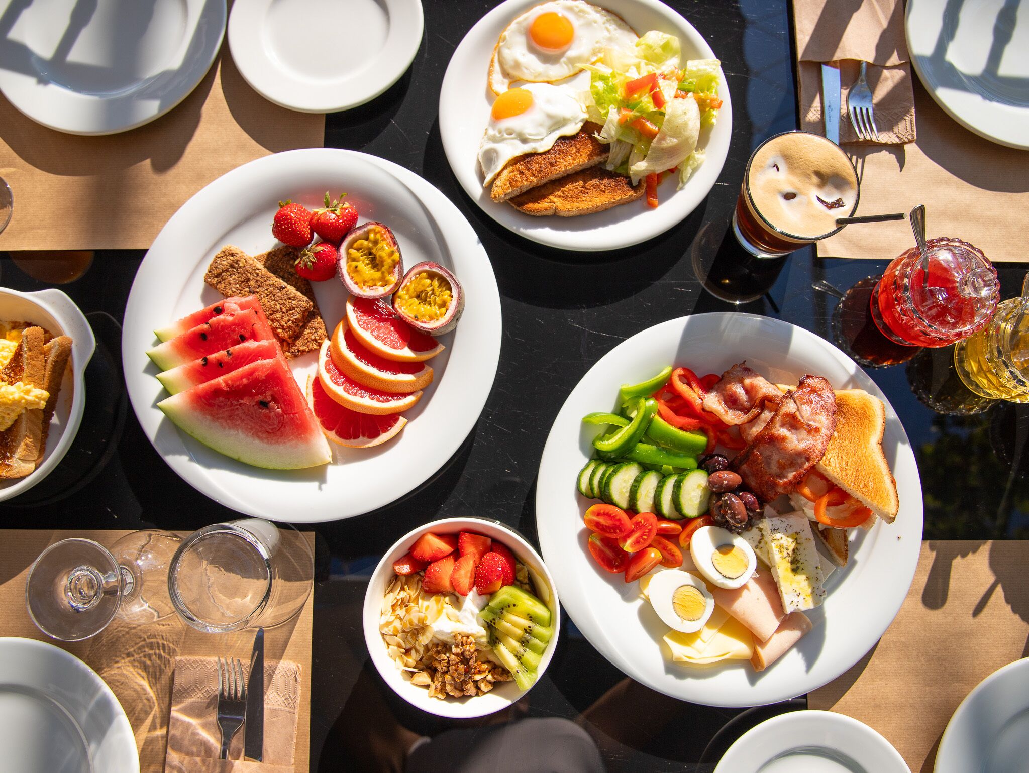 A table set with various breakfast dishes, including toast, eggs, and fruit.
