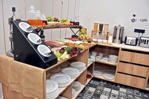 A buffet setup with various food items, plates, and a coffee station. - Linda Port Hotel (Istanbul)