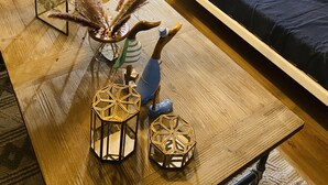 Un salón acogedor con sofá, cojines decorativos, lámpara colgante y suelo de madera.