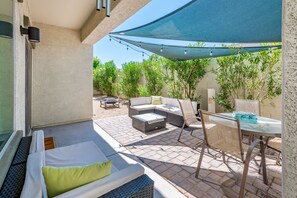 A patio area with a sofa, chairs, a table, and a canopy. - Modern, 3 Bedroom Home Near Superstition Mountain! (Apache Junction)