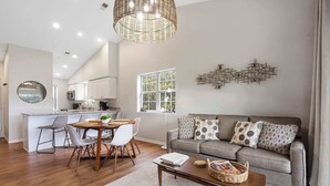 A modern living room with a grey sofa, a coffee table, and a dining area with a round table and chairs. - Whiskey's Hillside Retreat -holiday Hills Branson - Golf Resort (Branson)