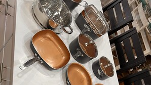 Une cuisine équipée de divers ustensiles de cuisine et de vaisselle, notamment des casseroles, des poêles et un plateau.