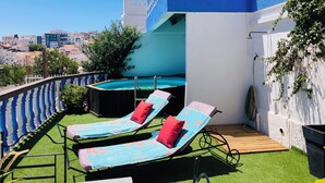 A rooftop terrace with two sun loungers, a small pool, and a view of the cityscape. - T1 Sunset View (Albufeira)