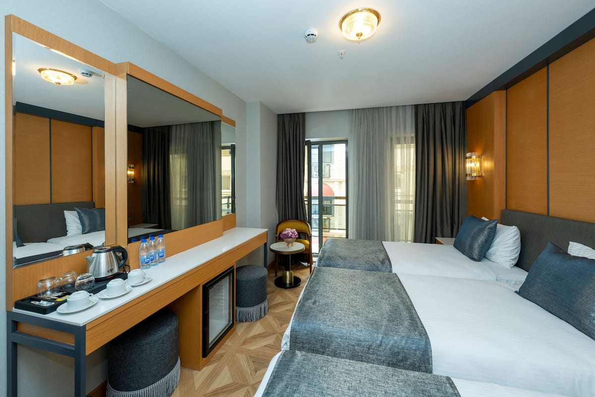 A hotel room with two beds, a desk with a coffee maker, and a chair.