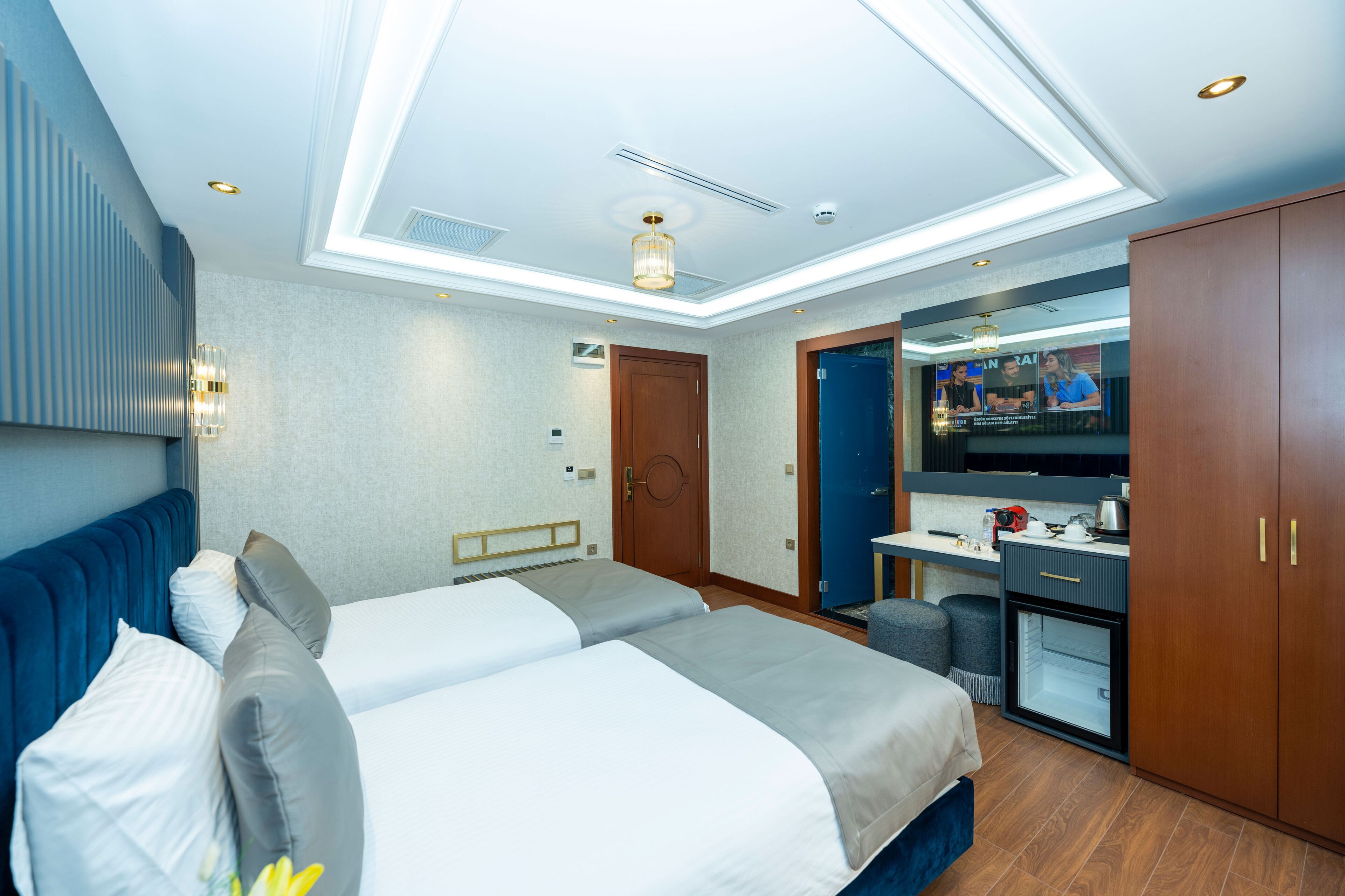 Una habitación de hotel moderna con una cama grande, un escritorio, un espejo y un televisor.