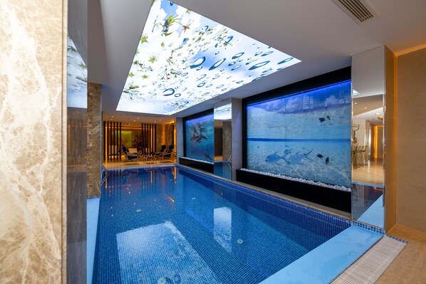 Een binnenzwembad en ligstoelen