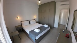 A modern hotel room with a large bed, a wardrobe, a bedside table, and a mirror. - Air house          . (Mykonos)